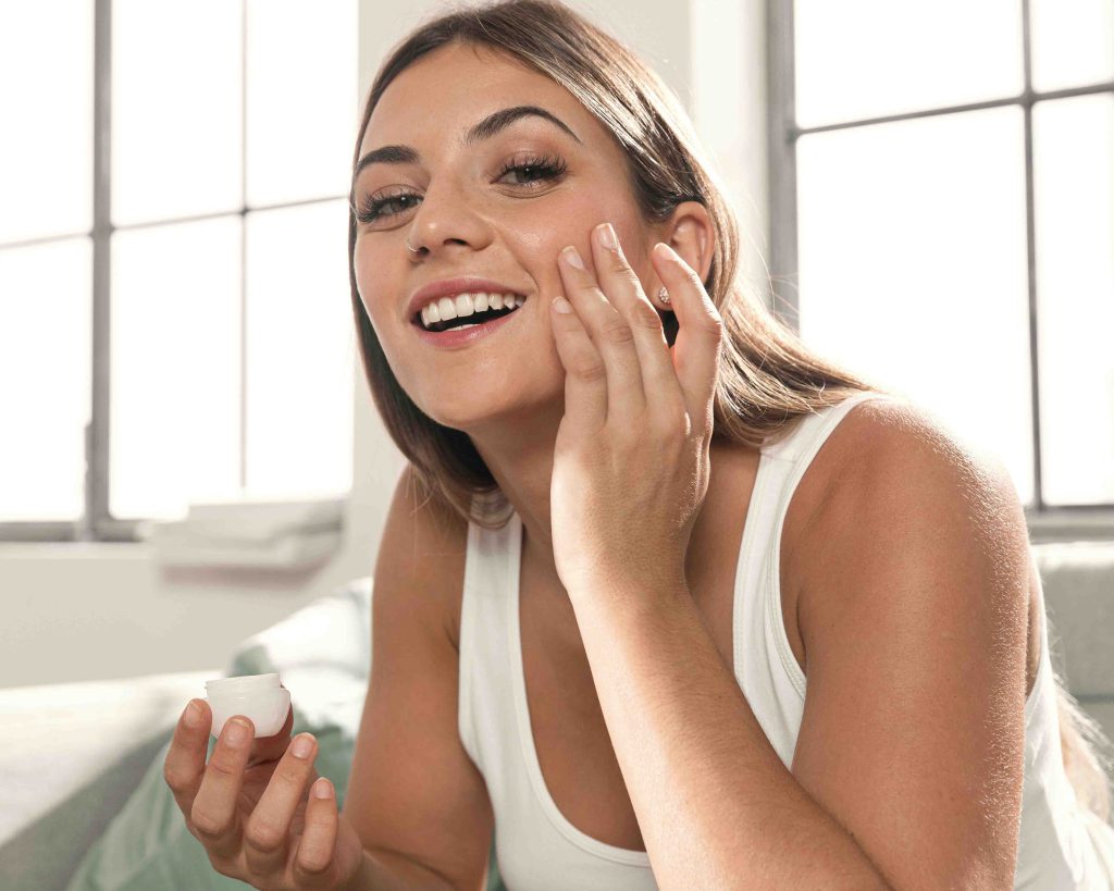 bella joven tratando productos belleza copia